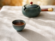 Heißer Tee im Sommer – dampfende Teetasse mit frischer Minze bei Sonnenlich