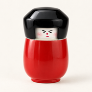 Kokeshi-Dose in Rot aus lackiertem Holz mit schwarzem Deckel auf cremefarbenem Hintergrund