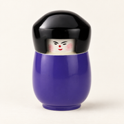 Kokeshi-Dose in Violett aus lackiertem Holz mit schwarzem Deckel auf cremefarbenem Hintergrund