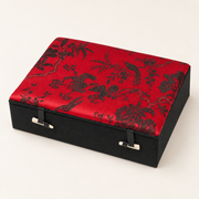 Geschlossene Schmuckkassette Rot, Klein, mit Blumen- und Pfauenmotiv sowie zwei Knebelverschlüssen.