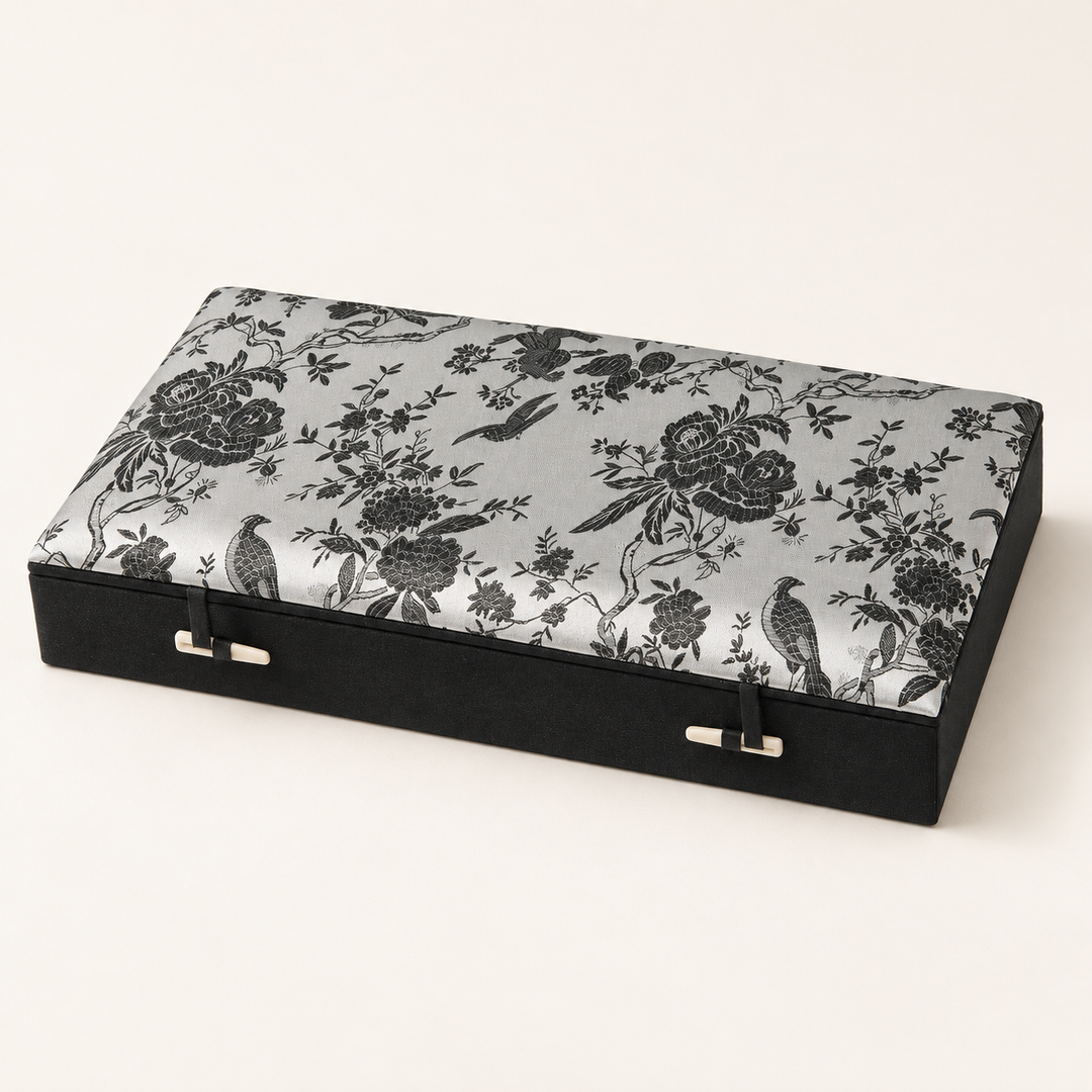 Geschlossene Schmuckkassette Silber, Groß, mit Blumen- und Pfauenmotiv sowie zwei Knebelverschlüssen.